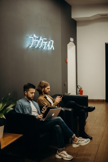 Two Men Sitting on Sofa Chairs