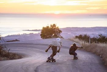 two men skating on downhill
