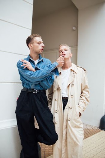 two men standing beside white painted wall