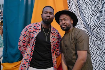 Two Men Standing Next to Each Other