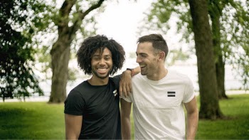 Two Men Standing on Grass Field