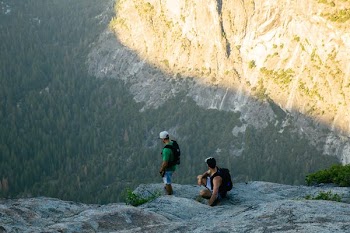 two men standing on rocky mountain cliff