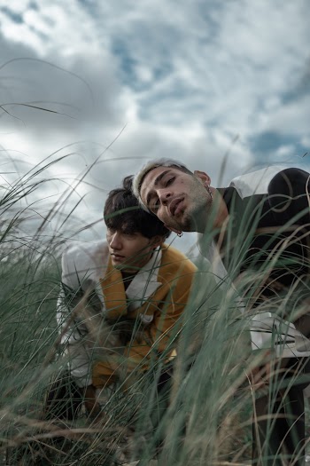 Two Men Surrounded by Grass