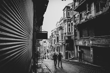 Two Men Walking on Street in Between Buildings