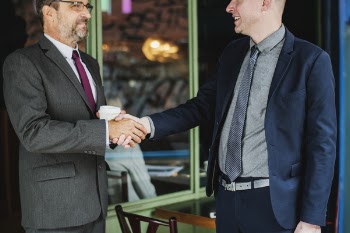 Two Men Wearing Suit Jackets Doing Hand Shake