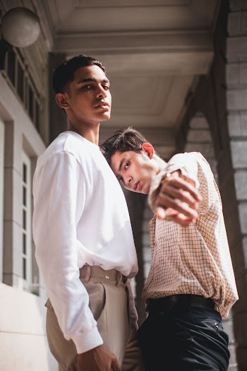 Two Men Wearing White Shirt and Plaid Button-up Shirt Standing Near Wall