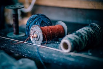 two orange and gray thread beside blue ball yarn on top of table