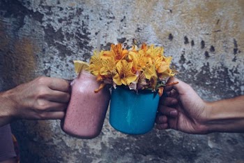 two people holding vases of flowers