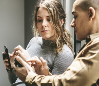 Two People in a Discussion with Mobile Phones