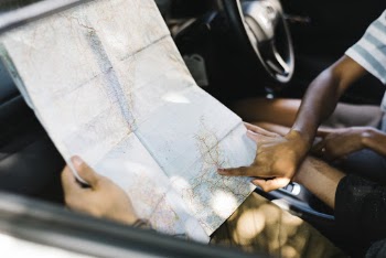 Two People In Vehicle Looking At The Map