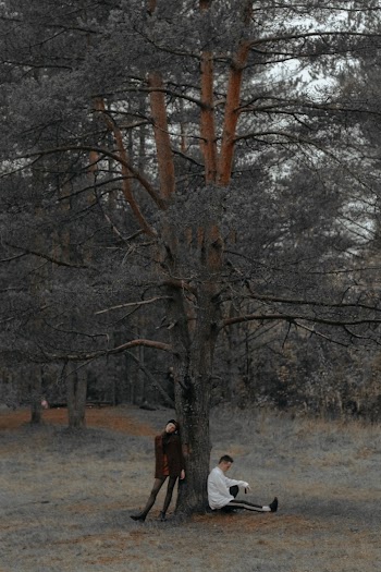 Two People Leaning on Tree