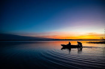 Two People On A Boat In Body Of Water 
