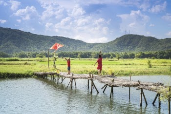Two People Running On Bridge Over Body Of Water