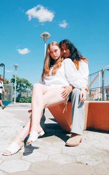 Two People Sitting In A Park 