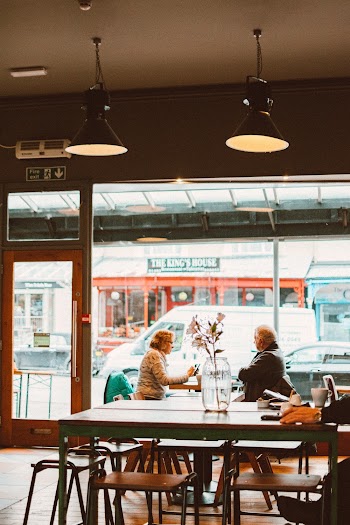 Two People Sitting Inside Cafeteria by the Glass Wall