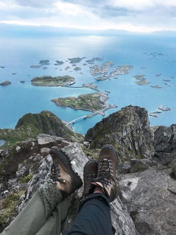 Two People Sitting Near Cliff