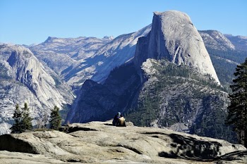 Two People Sitting on Mountain Edge