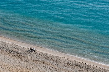 two people sitting on shore