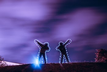 Two People Standing on Hill at Night Time