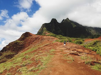 Two People Standing on Mountain Under White Sky
