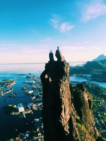 Two People Standing on Top of Mountain With Views of City in Port