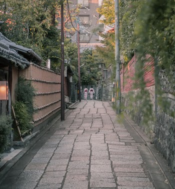Two People Walking In A Alley