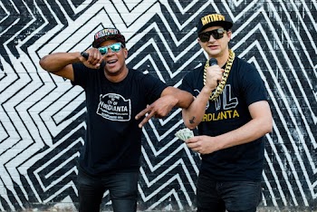 Two People Wearing Black Shirts Standing Near Wall