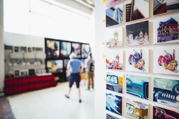 Two Person in Near a Photo Collage in a Room