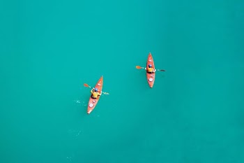 two person kayaking on open body of water