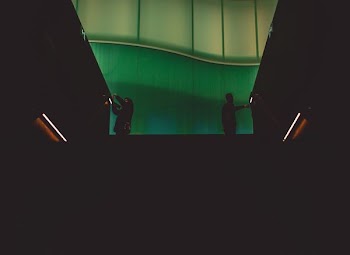 two person's silhouette standing near wall