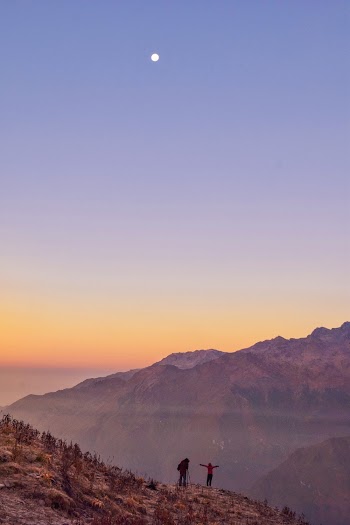Two Person Standing Near Cliff during Golden Hour