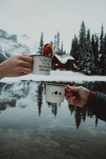two person toasting their cups outdoors