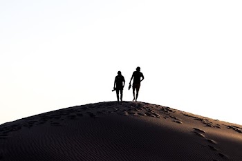 two person walking on desert