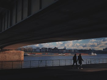 Two Person Walking Under Bridge