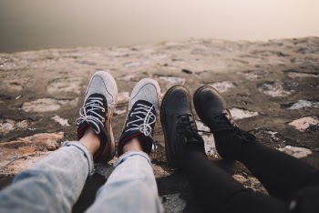 Two Person Wearing Pants and Shoes Sits on Ground at Daytime