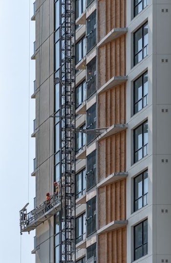 two persons on cleaning buildings window