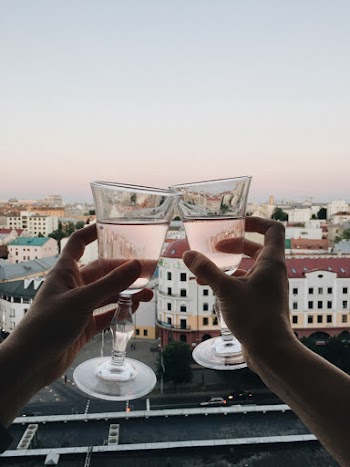 Two Persons Tossing Clear Wine Glasses