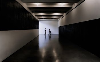 two persons walking towards white and black building