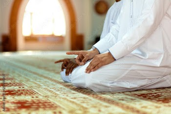 Two religious muslim man praying together inside the mosque