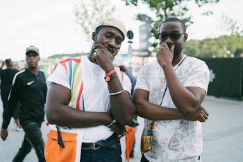 Two Smiling Men Covering Faces With Left Hands