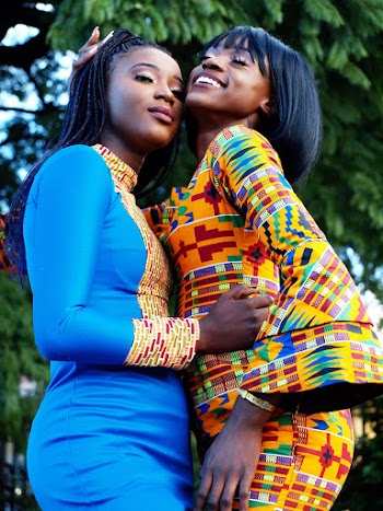 Two Smiling Women Standing Side By Side