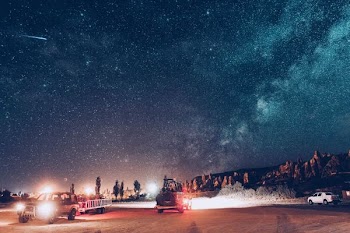 two vehicle on road near rock formation at nighttime