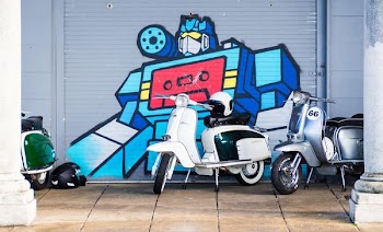 two white and blue motor scooters beside gray steel robot-printed shutter door