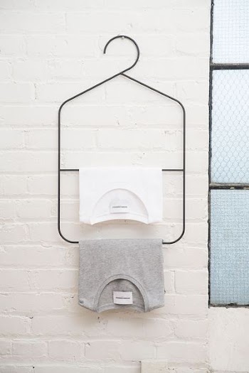 two white and heather gray shirts hanged on white wall