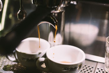Two White Ceramic Cups Filling With Coffee