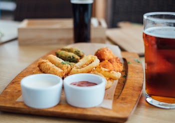 Two White Ceramic Sauce Containers on Brown Wooden Board