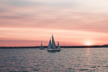 Two White Sailboats On Body Of Water