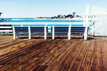 Two White Wooden Bench Near White Wooden Rails