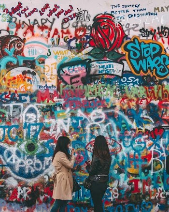 two woman beside wall