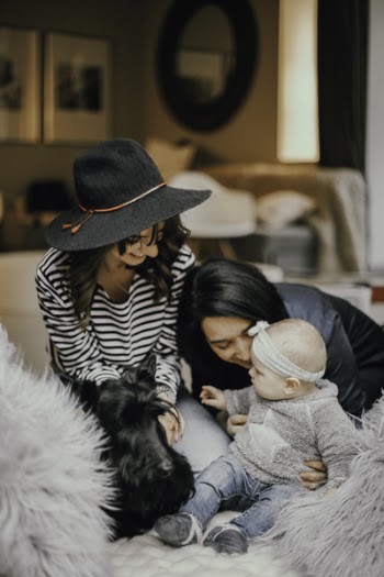 Two Woman Playing and Smiling With Baby on Sofa